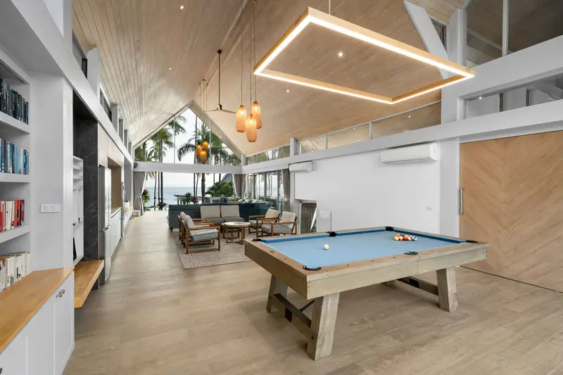 Pool table, lounge seating and high timber ceilings inside the villa living pavilion.