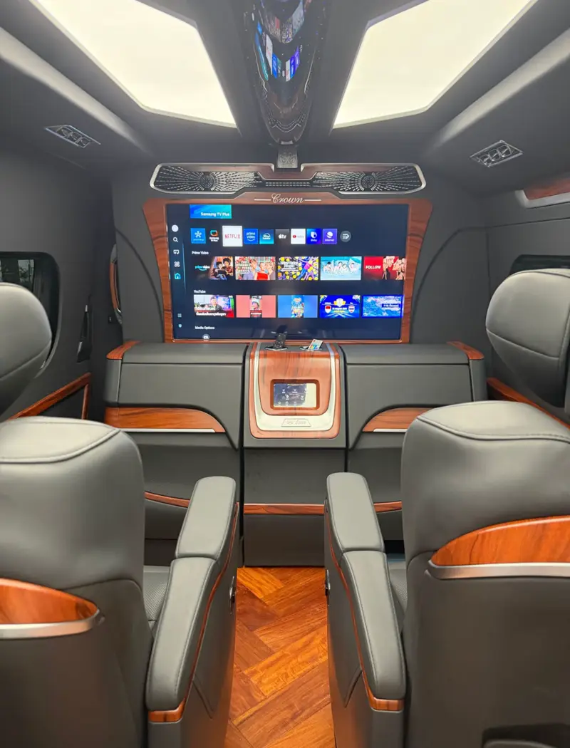 The van’s cabin with reclining leather seats, a large screen and ambient lighting.