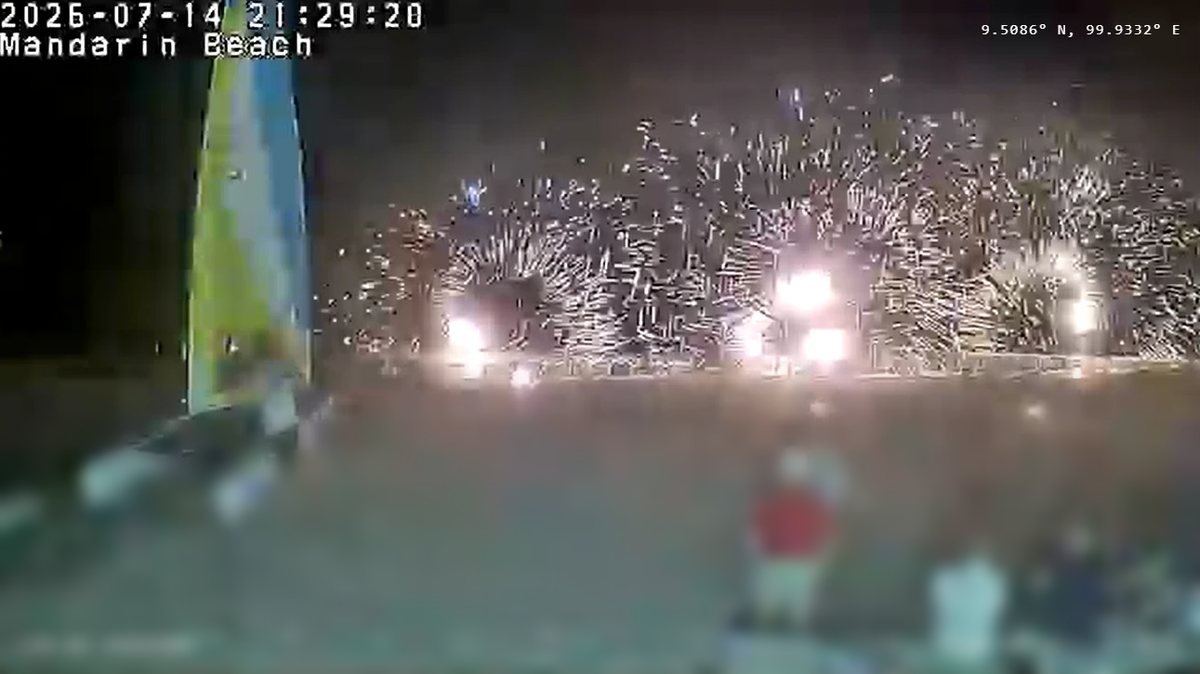 A wide spray of golden sparks across the beach in front of Mandarin Beach Villa, Lipa Noi, captured on the live webcam at 21:29 on 14 July 2026
